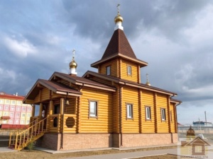 Фасад дерев’яної церкви з ганком та оциліндрованої колоди